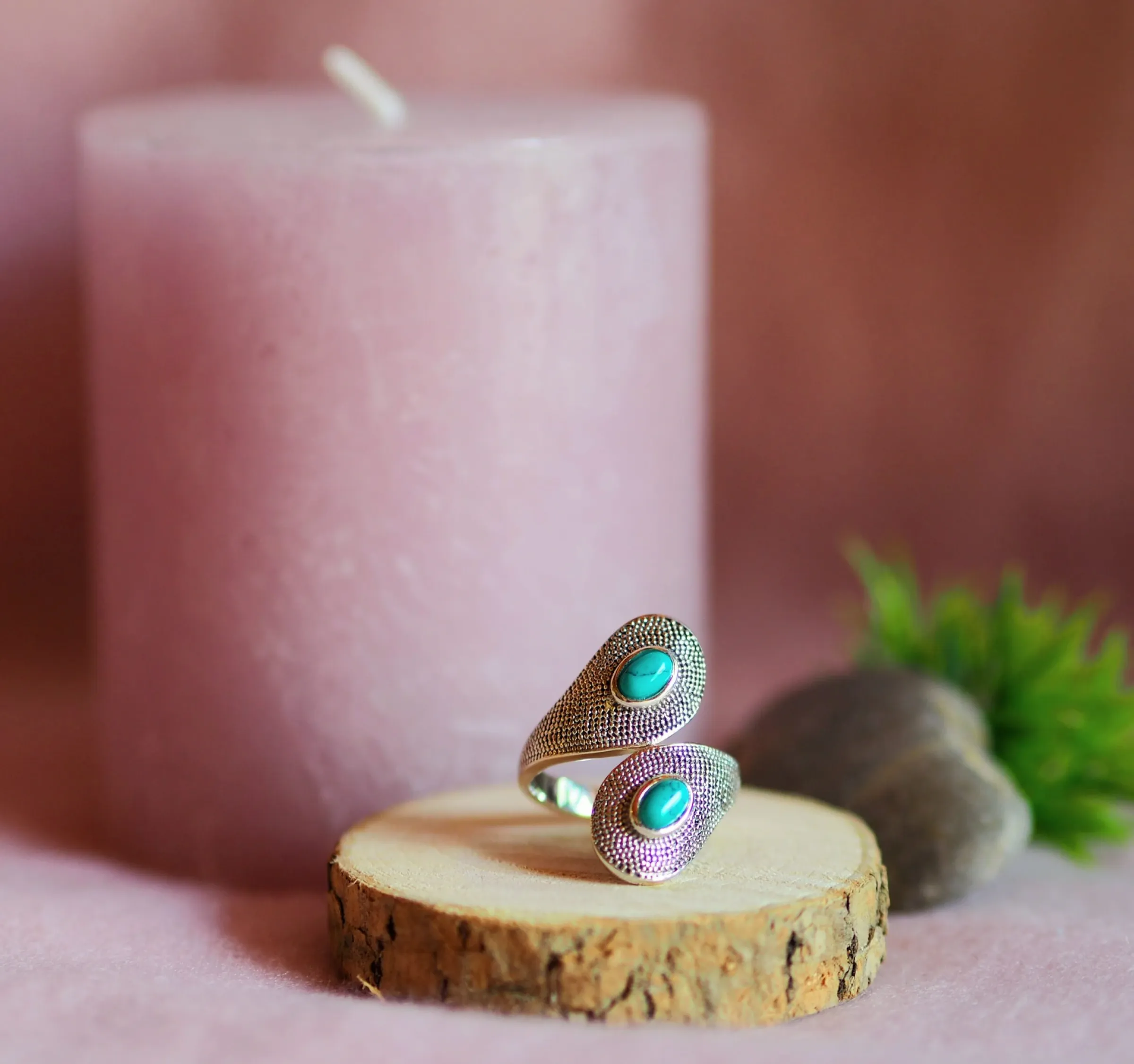 Bague ouverte en argent ciselé, aux deux extrémités croisées serties d’une turquoise ovale, posée sur une rondelle de bois