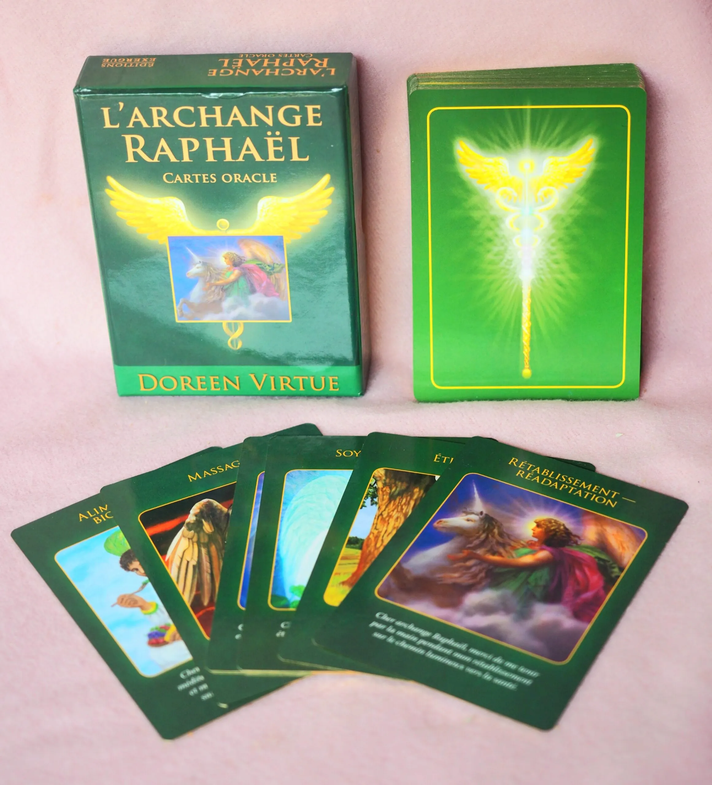 Coffret vert « L’archange Raphaël, cartes oracle » de Doreen Virtue, son paquet de cartes et cinq cartes illustrées étalées