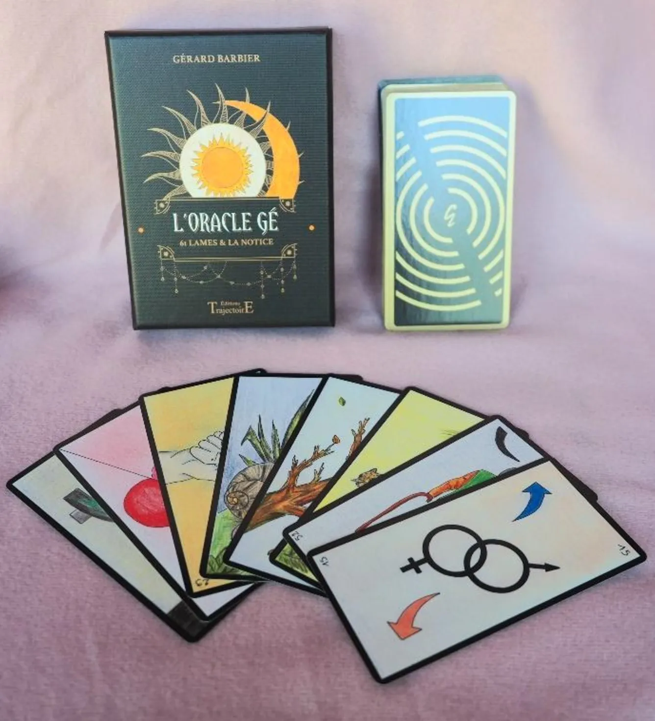 Coffret de l’Oracle Gé de Gérard Barbier, son paquet de cartes et sept cartes illustrées étalées en éventail